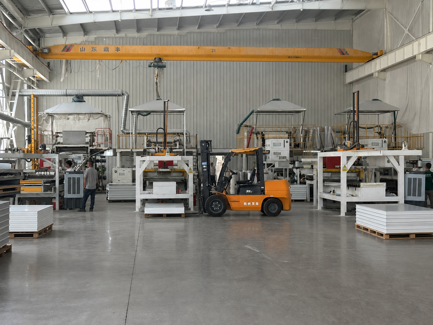 Clean SPC stone crystal wall panel production workshop with forming machines, forklift and stacked panels